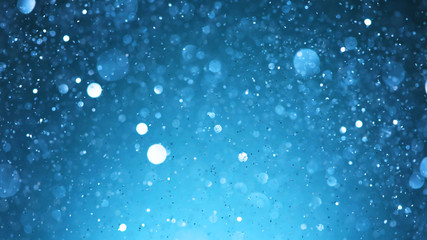 Abstract blue glittering background with blur dots.