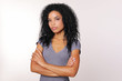 © My Ocean studio - Reserved woman. Serious adult woman with tanned complexion and Afro hairstyle is looking to the camera with her arms folded.