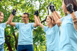 © Viktoriia - Volunteering. Young people volunteers outdoors standing together holding hands smiling successful