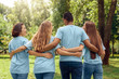 © Viktoriia - Volunteering. Young people volunteers outdoors walking hugging back view talking laughing cheerful