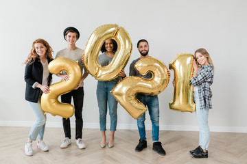 Canvas Print - Joyful boyfriends and girlfriends in casualwear showing number of the next year