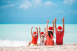 © travnikovstudio - Happy family with two kids in Santa Hat on summer vacation