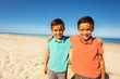 Two twin boys brothers hug on the sand sea beach