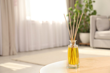 Canvas Print - Reed air freshener with essential oil on table in room. Space for text