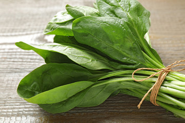 Bunch of fresh green healthy spinach on wooden table, closeup