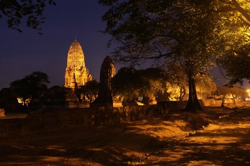 Canvas Print - temples at ayuthaya in thailand surrounded by trees at night time