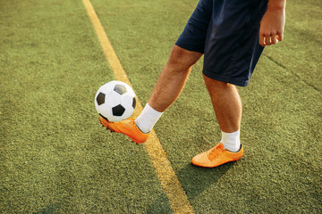 Male soccer player with ball standing on line