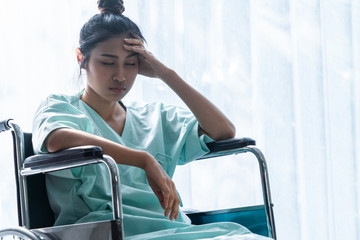 Serious patient sitting on wheelchair in hospital ward. Bad health result make the patient unhappy. Medical malpractice concept.