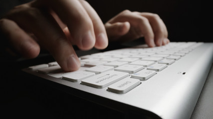 Wall Mural - close-up soft-focus finger typing on keyboard. man hand using laptop computer in office. programming