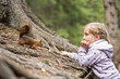 canvas print picture - Mädchen füttert Eichhörnchen mit einer Haselnuss, Europäisches Eichhörnchen (Sciurus vulgaris)