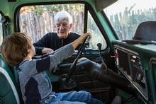 Senior Grandfather And His 6 Year Old Grandson In Vintage Pick Up Truck