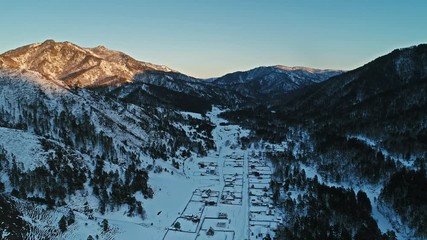 Wall Mural - A beautiful aerial shot of winter village, mountain winter resort in Altai