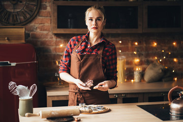 Canvas Print - Christmas and New Year celebration traditions. Family home bakery, cooking traditional festive sweets. Woman cutting cookies of raw gingerbread dough