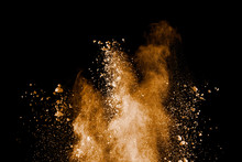 Freeze Motion Of Brown Dust Explosion.Stopping The Movement Of Brown Powder. Explosive Brown Powder On Black Background.