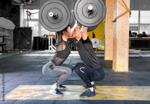Fotografía Fitness couple making a Barbell Jerk and kissing each other