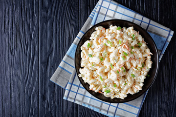 cold macaroni salad in a black bowl