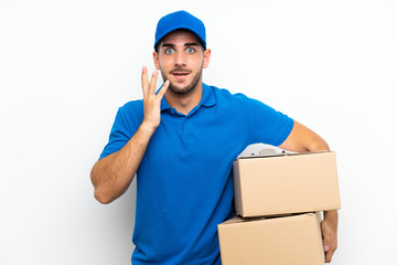 Delivery man over isolated white background with surprise facial expression