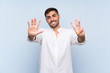© luismolinero - Handsome man with beard over isolated blue background counting eight with fingers