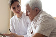 © fizkes - Older man patient and young nurse talking indoors