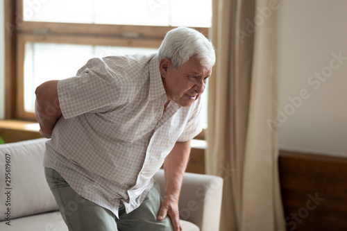 Fotografía Senior man got up from couch felt low back pain