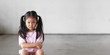 © kornnphoto - Asian child cute touchy or kid girl sitting face frown and angry aggressive with sad or have problems and lonely unhappy or wayward on city street and footpath at home or nursery and school with space