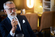 © alfa27 - Elderly man vaping in closed public space. Smoking electronic cigarette in restaurant. Way to overcome nicotine addiction, old habit. Using cigarette on places smoking is not allowed