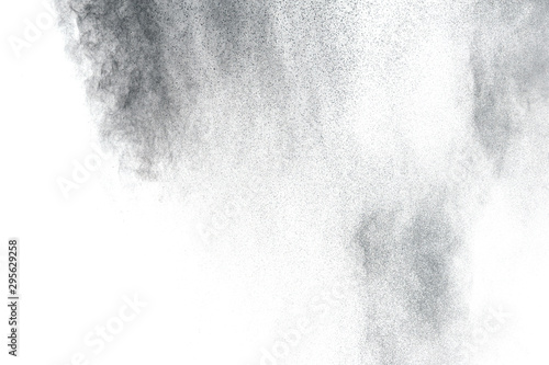 Black powder explosion on white background.Black dust particles splash.