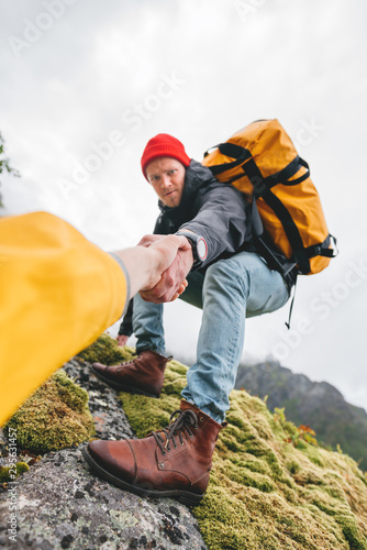 Fotografía POV view on brave tourist helping his active friend holding to hand climbing to rock