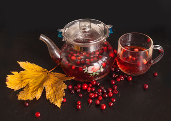 Warming cranberry tea on a black table. Autumn concept.