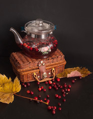 Warming cranberry tea on a black table. Autumn concept.