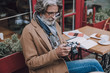 © Yakobchuk Olena - Calm man with camera at the table stock photo