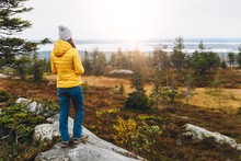 Woman Traveler In Yellow Jacket From Back Hike In Autumn Forest In Finland Lapland.