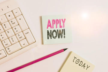 Text sign showing Apply Now. Business photo showcasing request something officially in writing or by sending in form White pc keyboard with empty note paper and pencil above white background