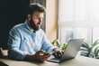 Creative worker using digital devices and programs in project. Corporate executive sitting at office desk, typing on laptop.