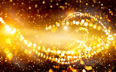 Poster - Golden Christmas and New Year glittering stars swirl on black bokeh background, backdrop with sparkling golden stars, holiday garland, magic glowing dust, lights. Gold Abstract Glitter Blinking sparks