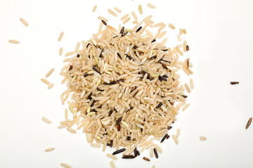 Wall Mural - handful of brown rice on a white table