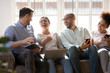 Happy diverse friends laughing at funny joke, using electronic devices
