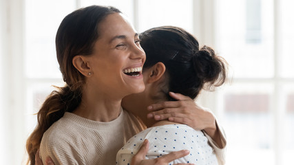 Wall Mural - Excited diverse best friends embracing and laughing close up