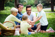 © NDABCREATIVITY - Multi generation family enjoying picnic in a park