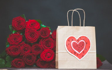 Wall Mural -  large bunch of red roses and a gift bag with a heart. The concept of a gift for Valentine's Day, love, wedding, date