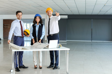 Wall Mural - Team of engineers discussing project of building indoors