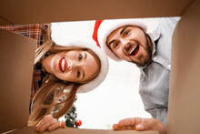 Happy Young Couple Opening Christmas Gift, View From The Box