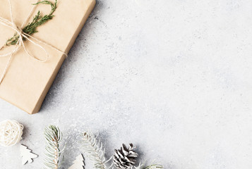 Christmas background. Christmas fir tree branches, gifts, pine cones on wooden white rustic background. Flat lay, top view. Copy space. Banner backdrop composition