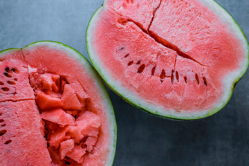 Two half ripe watermelon on a gray background. Soft focus.