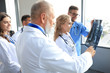 © ty - Group of doctors checking x-rays in a hospital.