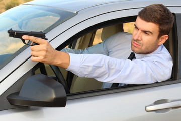 Secret agent holding gun while driving