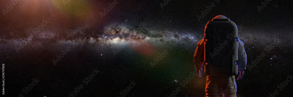 standing astronaut in front of the beautiful Milky Way galaxy - obrazy, fototapety, plakaty 