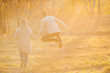 © Parilov - Loving couple walks in autumn park, man jumps from happiness. First love concept