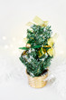 Small Christmas tree with golden ornaments and white background, Christmas decoration