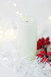White candle surrounded by christmas ornaments, white Christmas pic with decorations